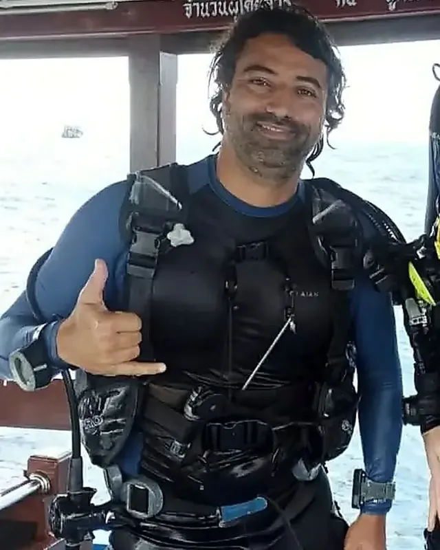 Plongeur souriant avec gilet et détendeur sur un bateau