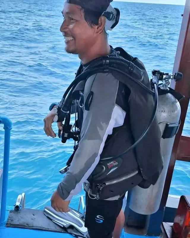 Plongeur souriant sur un bateau avec son équipement complet