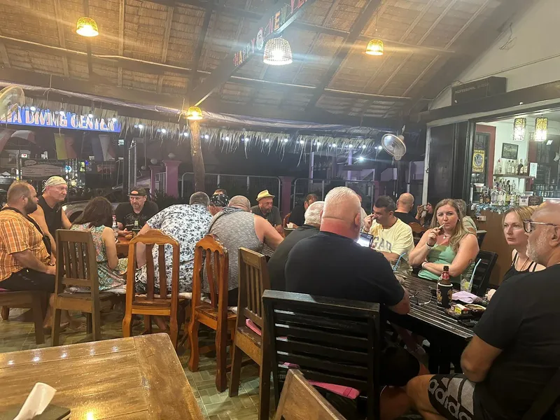 Groupe de personnes assises au bar d'un centre de plongée