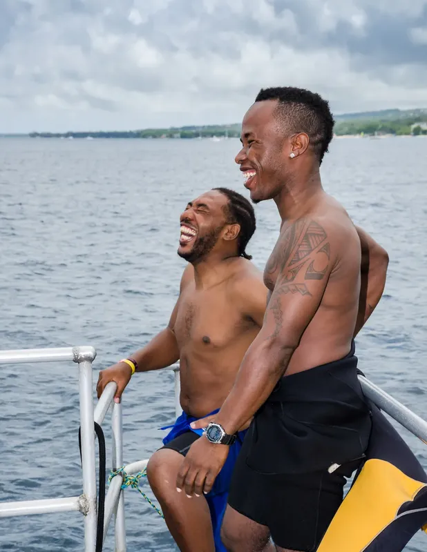 Deux hommes souriants et riant à bord d'un bateau en mer