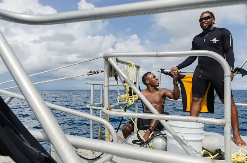 Deux plongeurs souriants sur le pont d'un bateau en mer