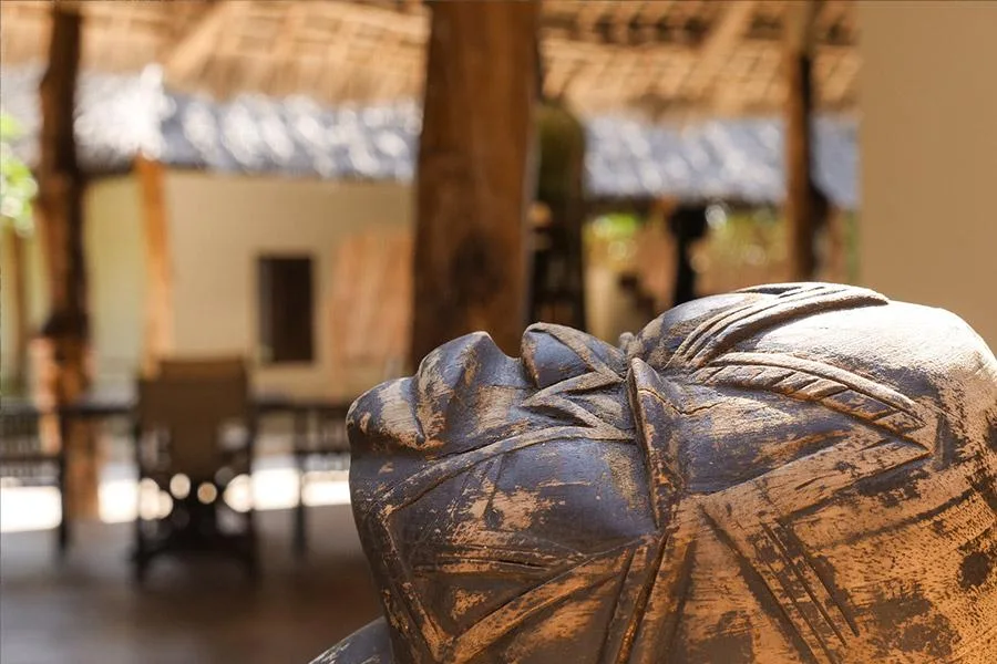 Statue de visage en pierre, arrière-plan flou d'une structure ouverte