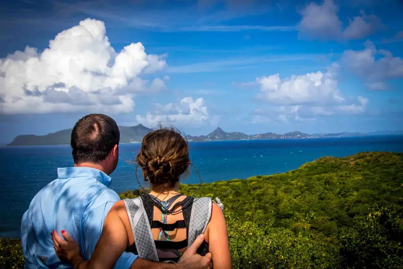 Couple regardant un paysage marin avec des îles et un ciel bleu