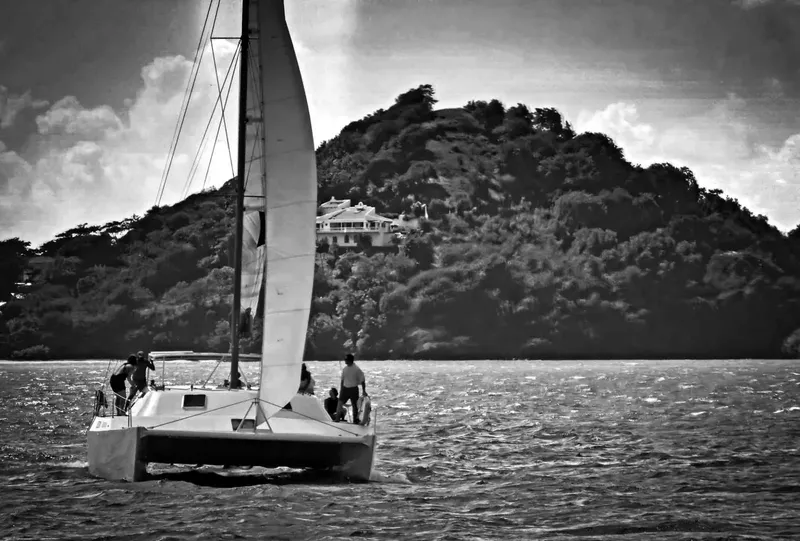 Catamaran en mer avec des personnes à bord, paysage montagneux