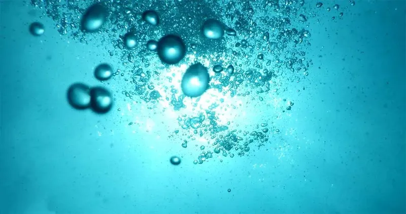 Bulles d'air remontant vers la surface dans l'eau turquoise