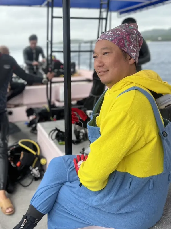Plongeur souriant assis sur un bateau avec son équipement