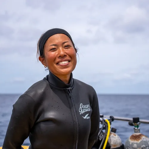 Femme souriante en combinaison de plongée sur un bateau en mer