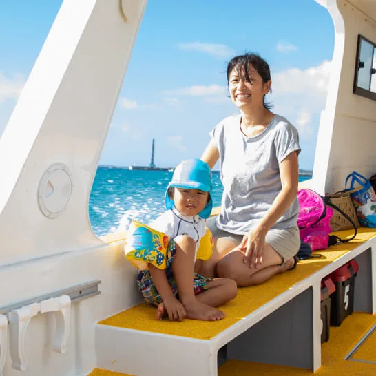 Mère et enfant souriants sur un bateau de plongée en mer