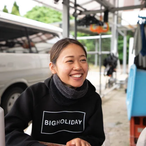 Femme souriante portant un sweat-shirt avec un texte blanc
