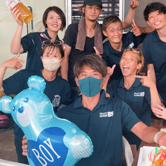 Groupe de personnes souriantes, certaines portent des masques et des t-shirts
