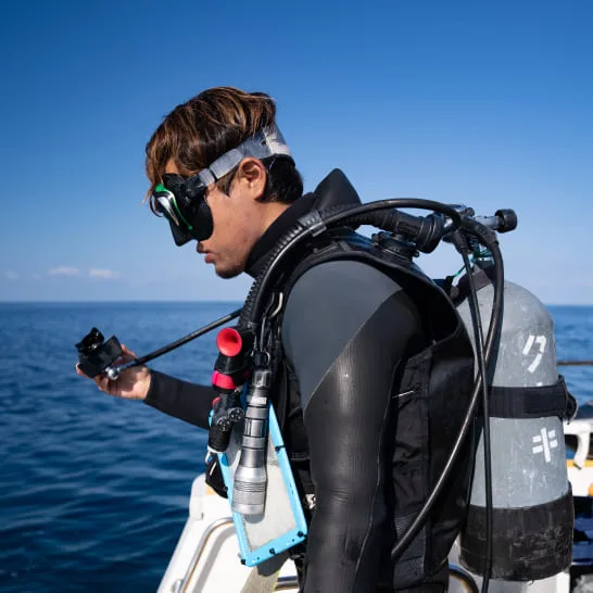 Plongeur équipé se prépare à plonger depuis un bateau en mer