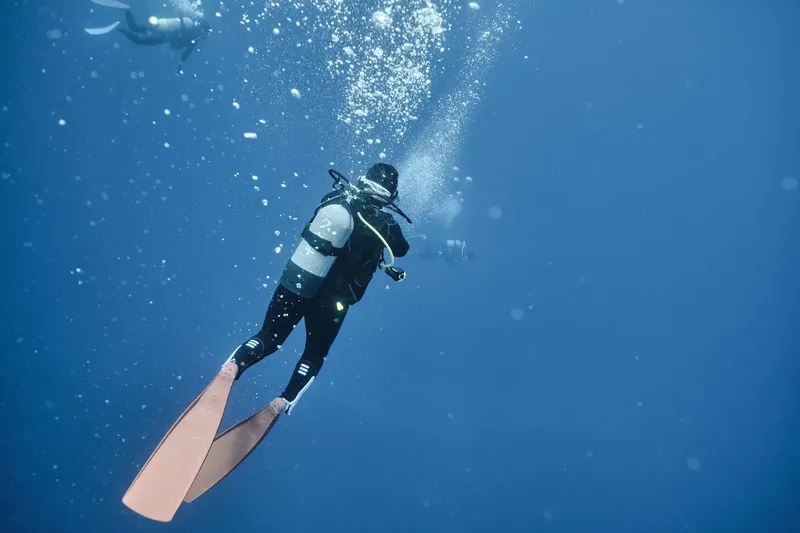 Plongeur en scaphandre explore les profondeurs bleues de l'océan