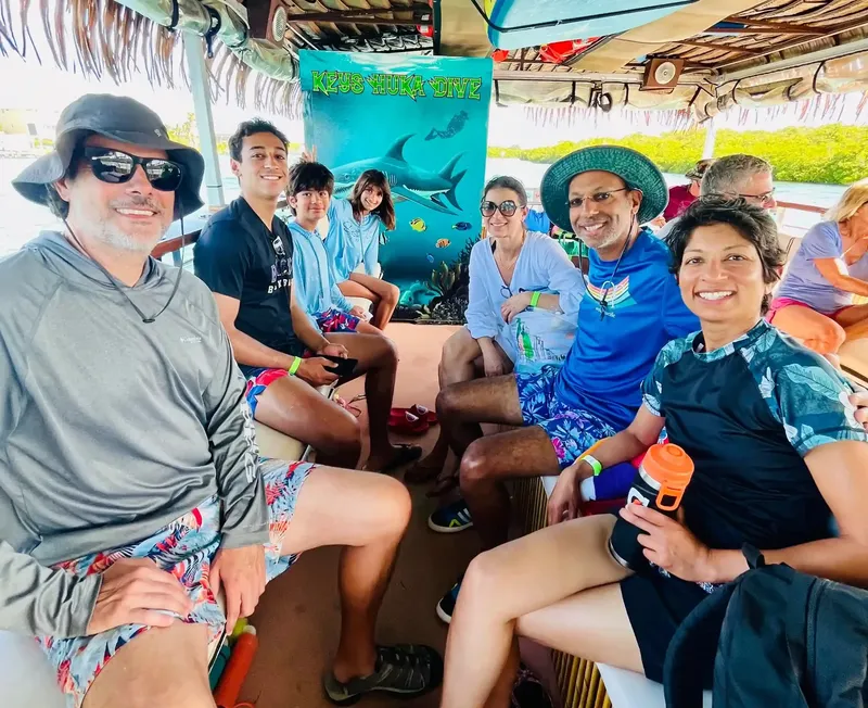 Groupe de personnes souriantes à bord d'un bateau de plongée en excursion