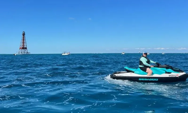 Une personne conduit un jet ski sur une mer bleue calme