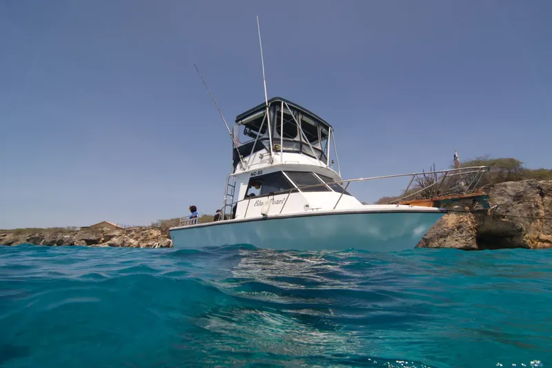 Bateau de plongée amarré près d'une côte rocheuse en eau turquoise
