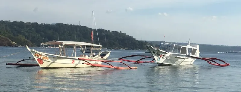 Deux bateaux de pêche traditionnels philippins amarrés dans une baie calme
