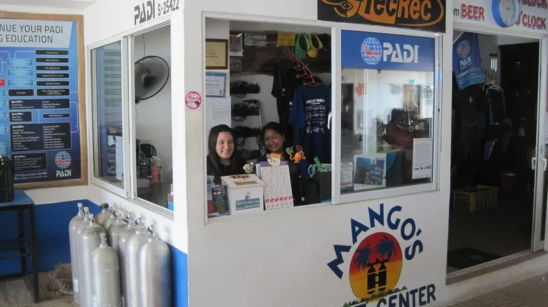 Deux employées souriantes derrière un comptoir dans un centre de plongée
