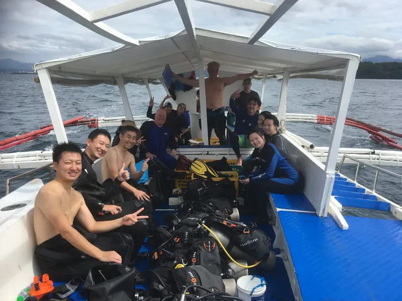 Groupe de plongeurs souriants à bord d'un bateau de plongée en mer
