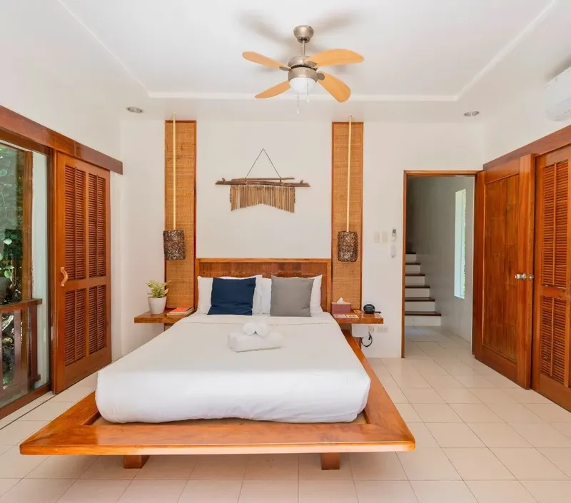 Chambre d'hôtel lumineuse avec lit double et décoration en bois