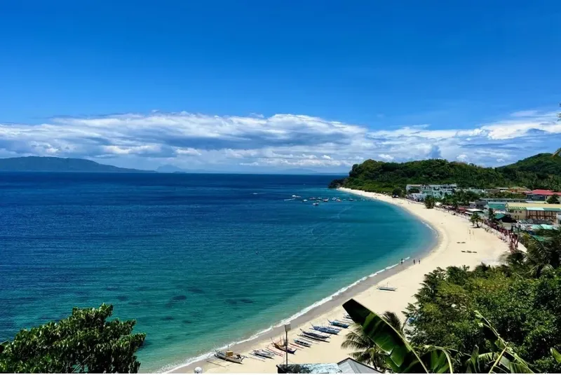 Vue aérienne d'une plage tropicale avec des bateaux et des personnes