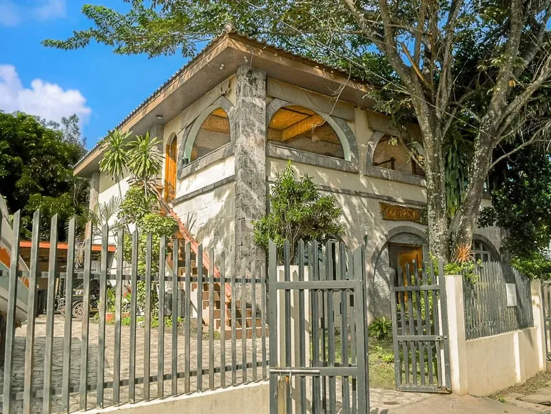 Bâtiment blanc avec des arches et une clôture métallique devant
