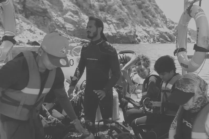 Préparation de plongeurs sur un bateau, vérification du matériel, ambiance détendue