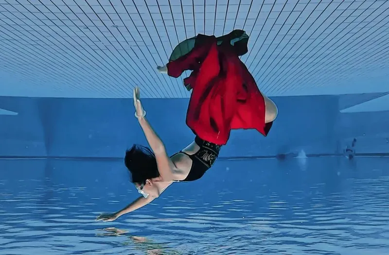 Femme en combinaison de plongée nageant sous l'eau dans une piscine