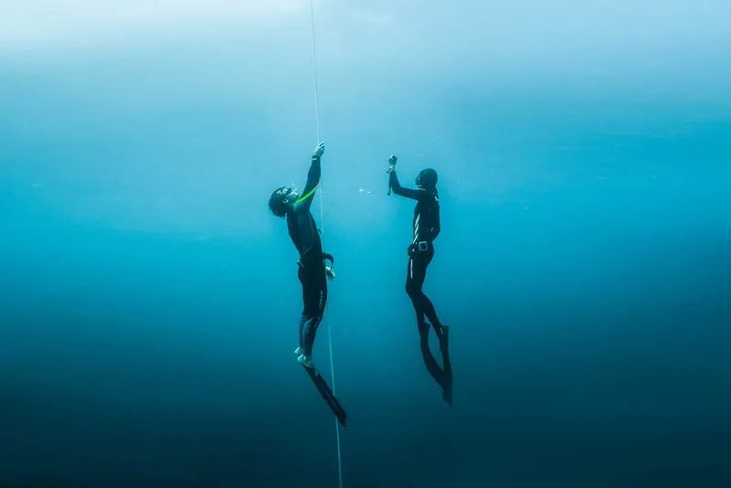 Deux apnéistes évoluent verticalement le long d'un guide sous-marin