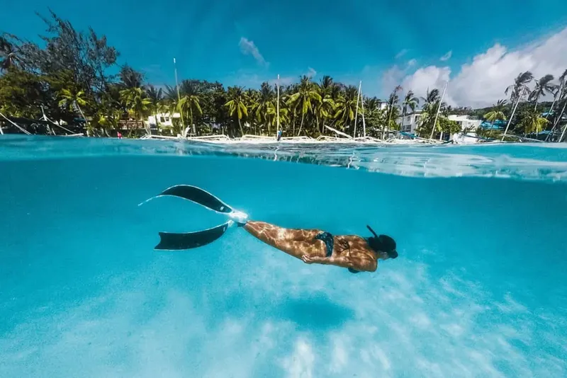 Apnée : une personne nage en surface dans une eau turquoise claire