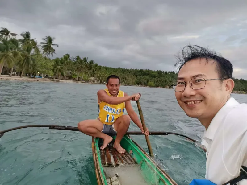 Deux hommes souriants dans un petit bateau en mer