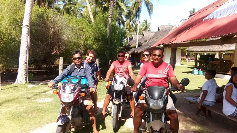 Groupe de personnes souriantes sur des scooters devant un bâtiment