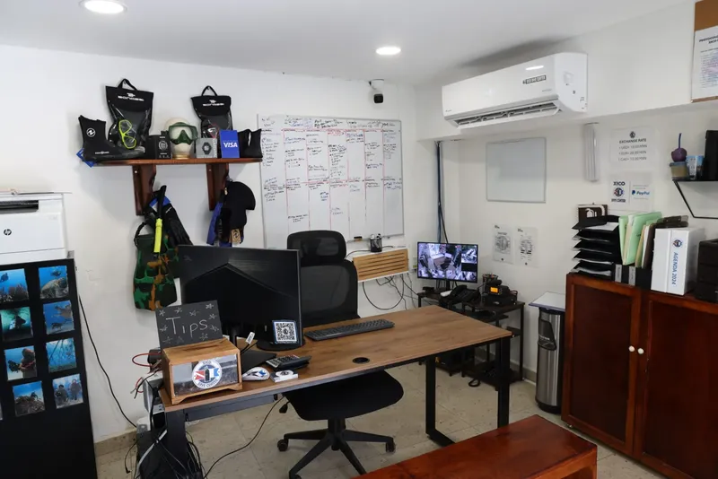 Bureau d'un centre de plongée avec matériel, ordinateurs et tableau blanc