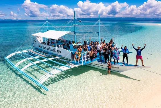 Groupe de personnes sur un bateau traditionnel dans une eau turquoise