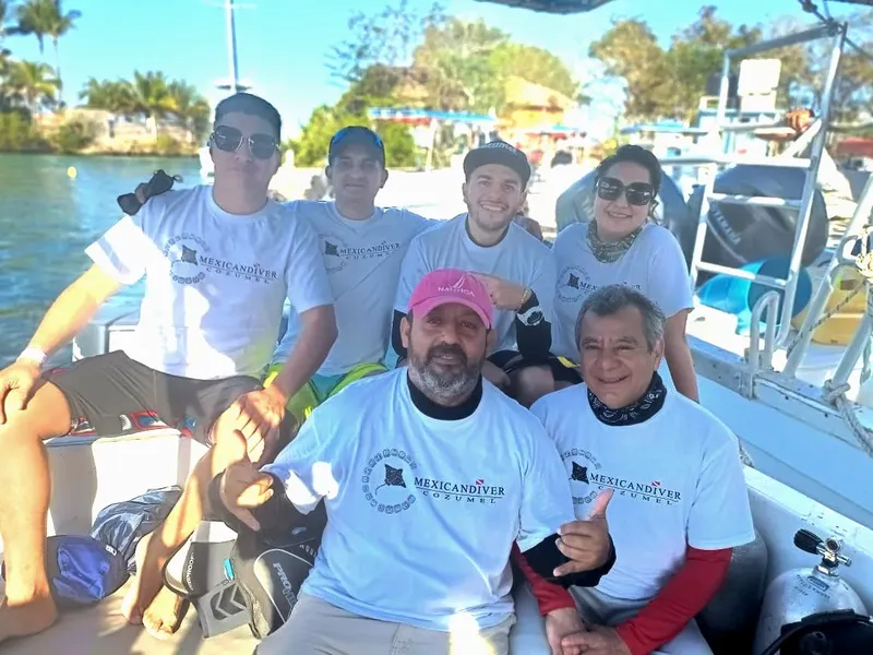 Groupe de personnes souriantes à bord d'un bateau de plongée en mer