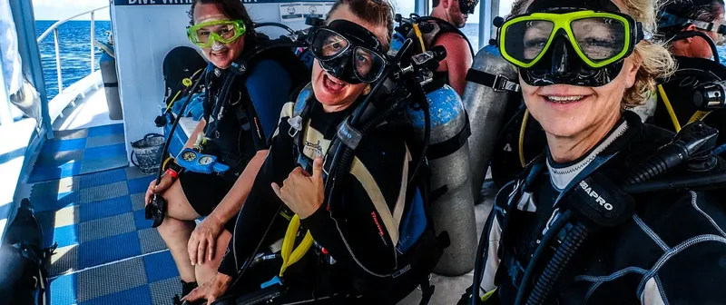 Plongeurs souriants équipés sur un bateau de plongée en mer