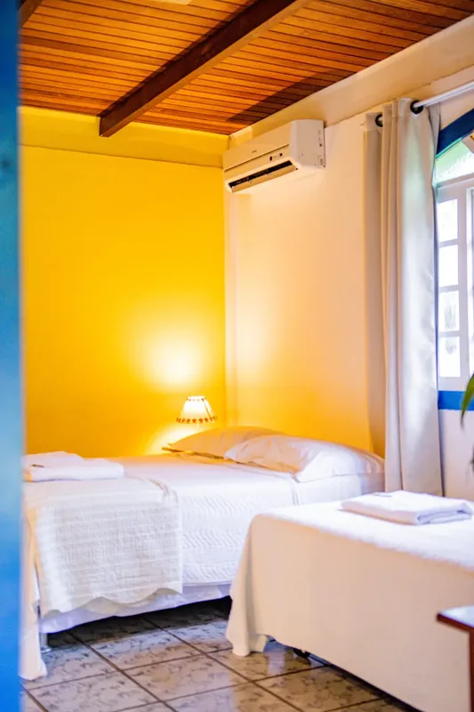 Chambre lumineuse avec deux lits simples et climatisation décorée