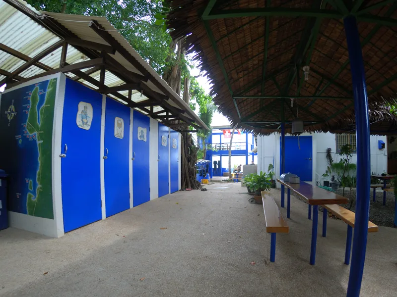 Terrasse couverte avec des vestiaires bleus et des bancs en bois