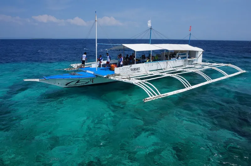 Bateau de plongée bleu et blanc avec des personnes à bord en mer