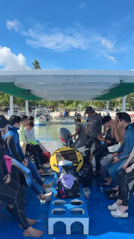 Groupe de plongeurs assis sur un bateau avec leur équipement