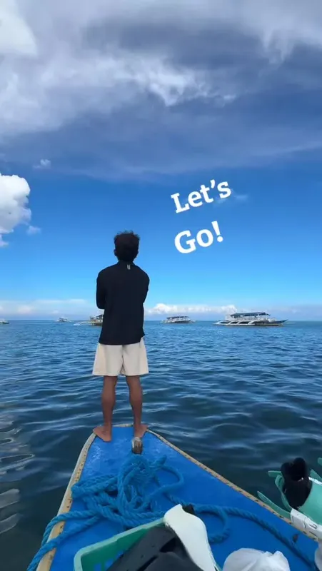 Homme debout sur la proue d'un bateau, regardant vers la mer
