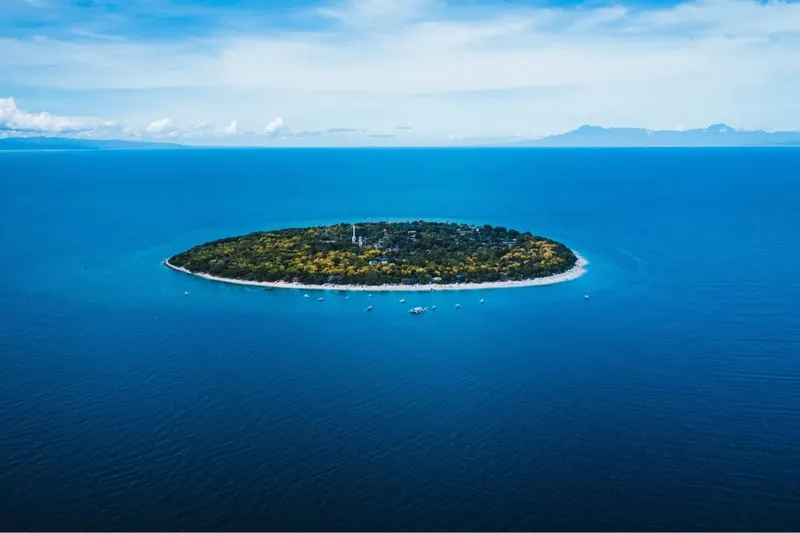 Vue aérienne d'une petite île tropicale entourée d'eau bleue