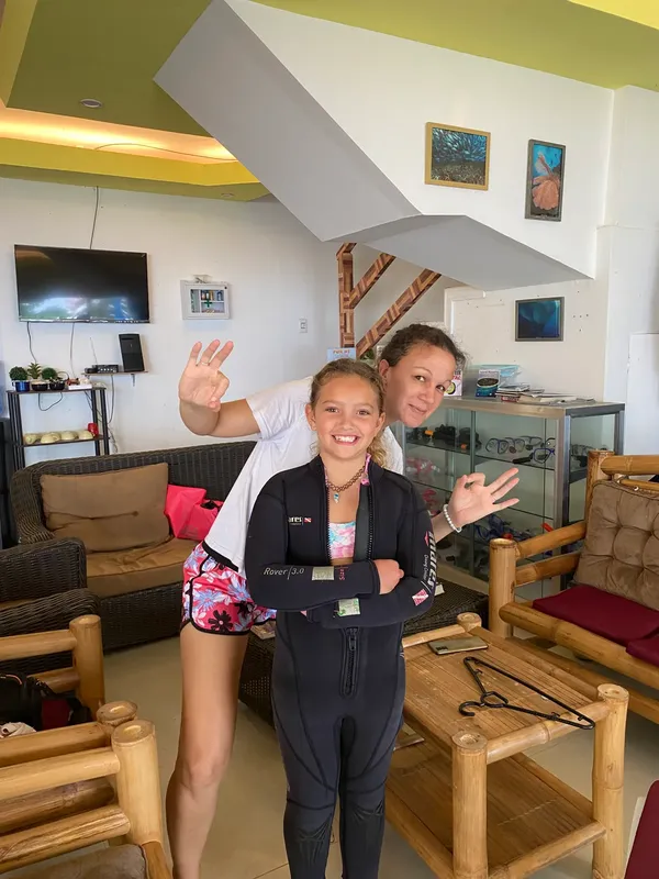 Deux jeunes filles souriantes, équipées pour la plongée, dans un centre