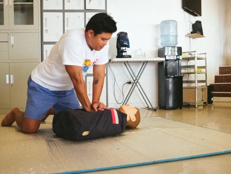 Un homme effectue un massage cardiaque sur un mannequin d'urgence