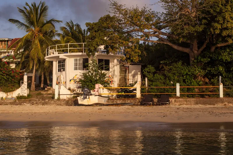 Bâtiment blanc avec un bateau sur la plage au bord de l'eau