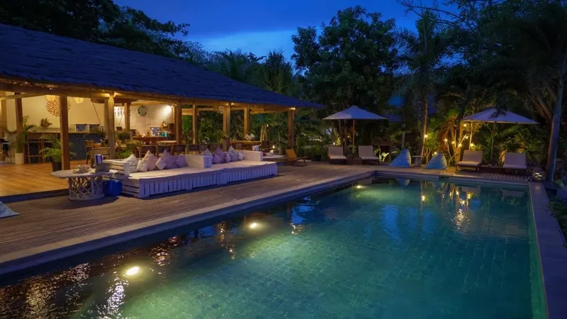 Terrasse en bois avec piscine éclairée et mobilier de détente extérieur