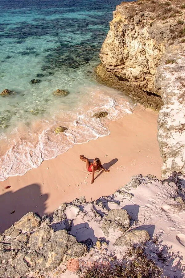 Une femme se détend sur une plage rocheuse au bord de la mer