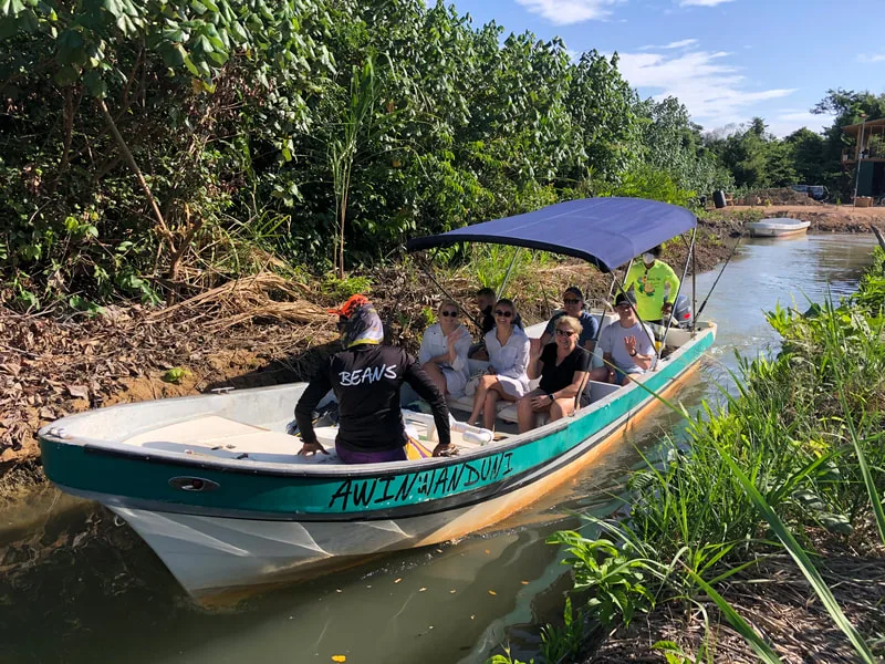 Groupe de personnes à bord d'un bateau vert sur une rivière