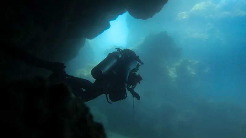 Plongeur explorant une grotte sous-marine avec une lumière vive