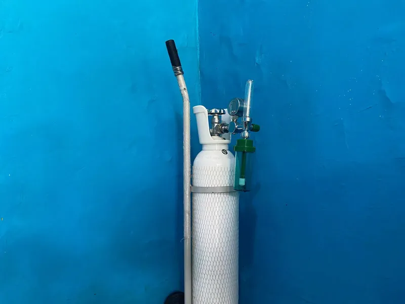 Bouteille de plongée blanche avec détendeur sur fond bleu uni