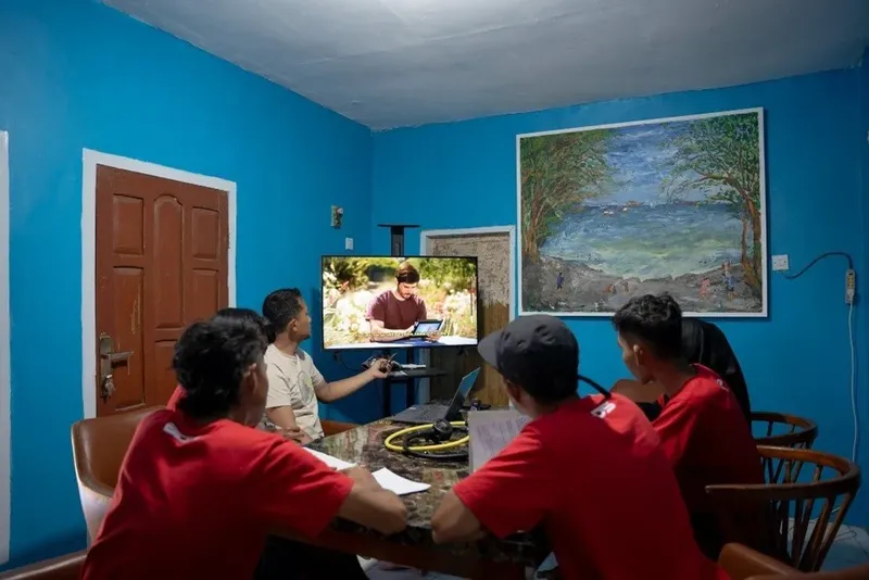 Groupe de personnes regardant une vidéo de plongée sur un écran